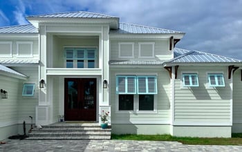 House with blue exterior Bahama shutters