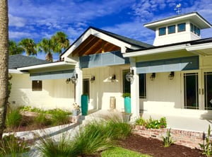 House with fixed panel aluminum shutters and palm trees in the background